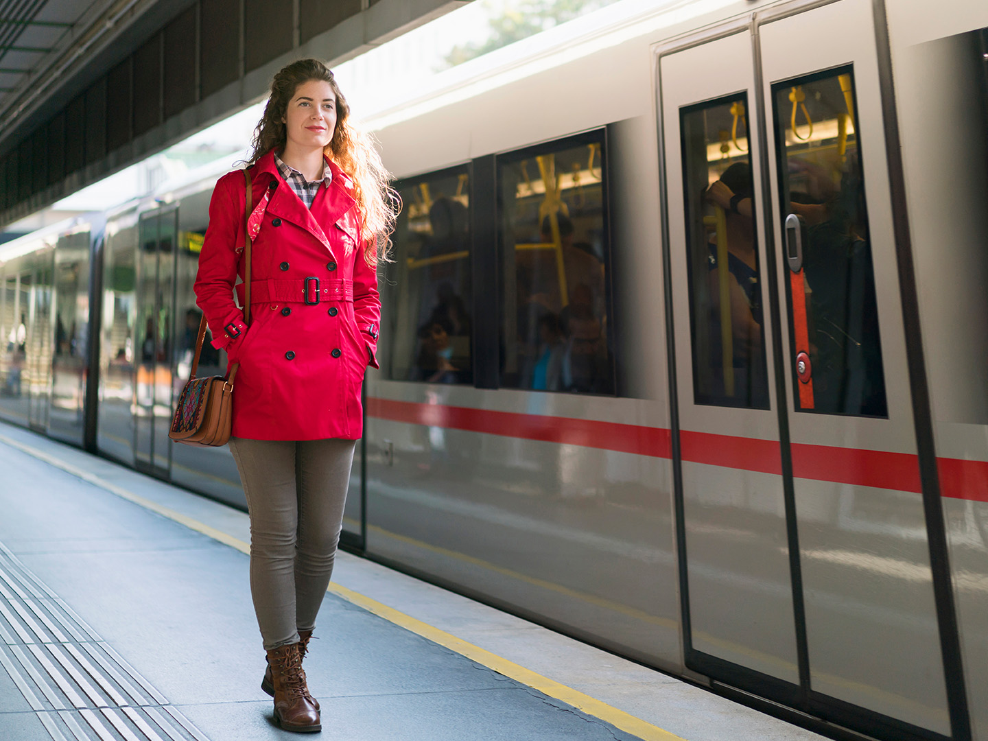 Foto: Frau in roter Jacke geht am U-Bahnsteig